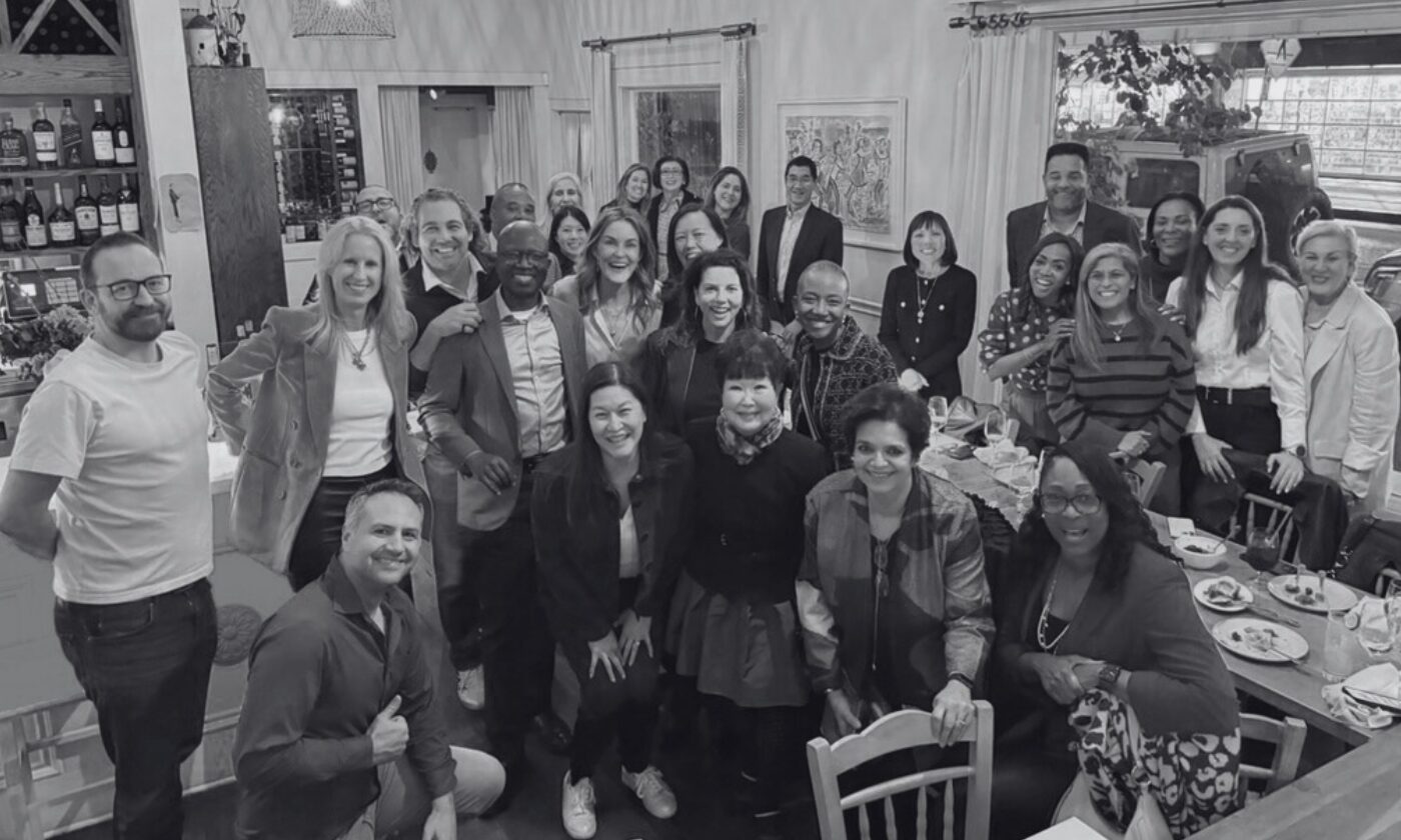 A group photo from an Alpha Council dinner with members gathered around a dining room.
